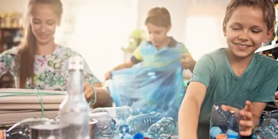 Des enfants trient des bouteilles en plastique pour les recycler à la maison.